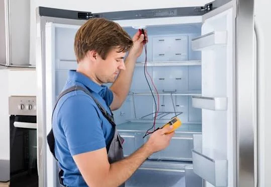 Technician using a multimeter to diagnose an open refrigerator