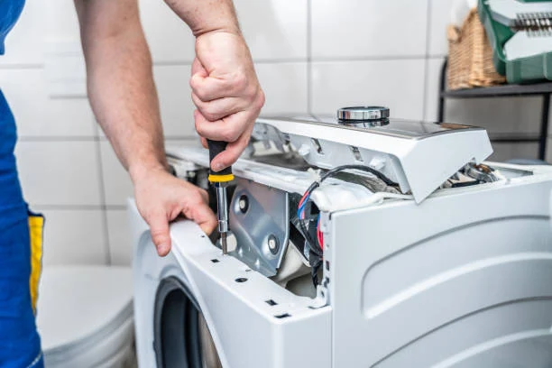 Close-up of a technician repairing the top panel of a front-loading washer